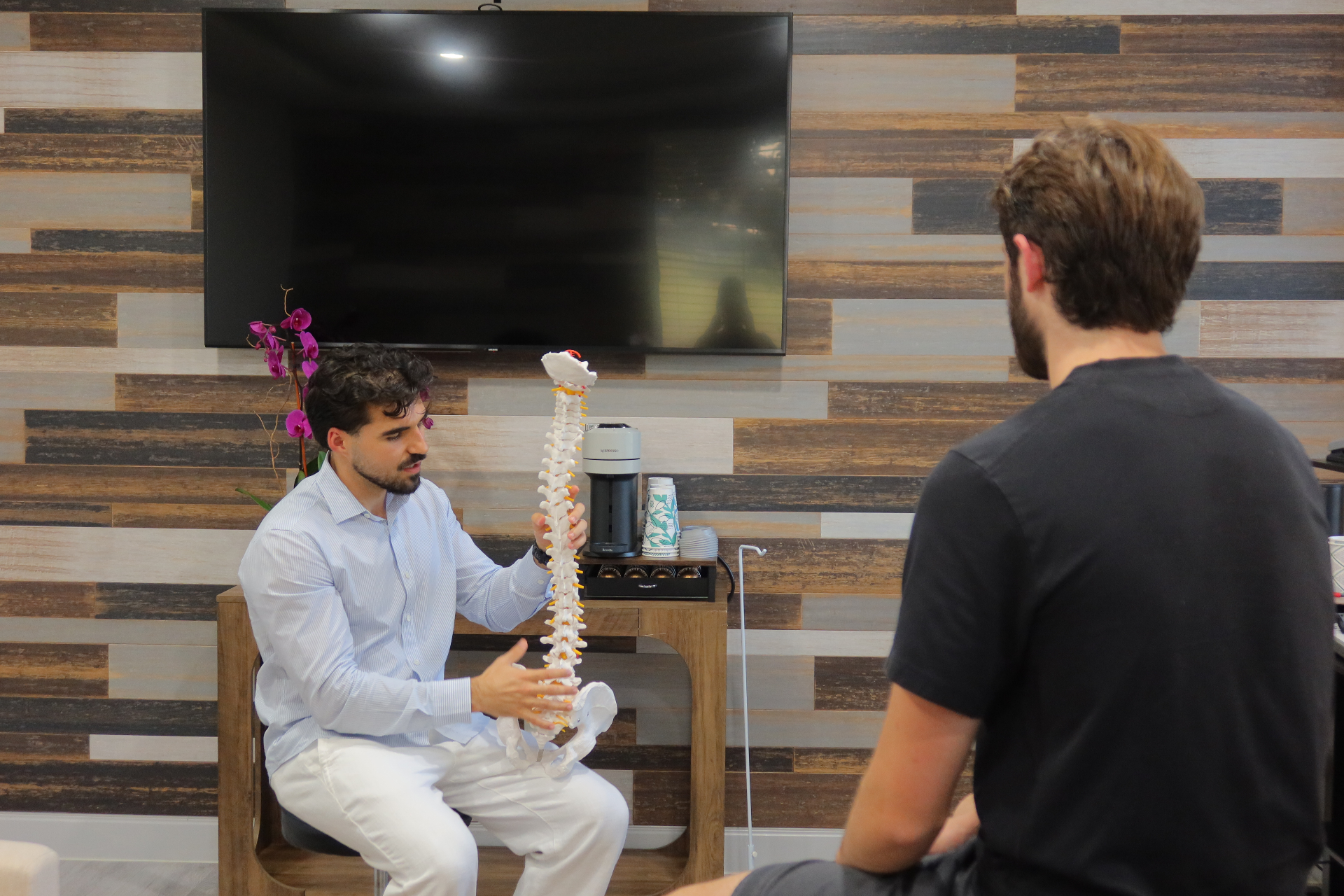 Dr. Rifati explaining the spine and nervous system to a patient using an anatomical model